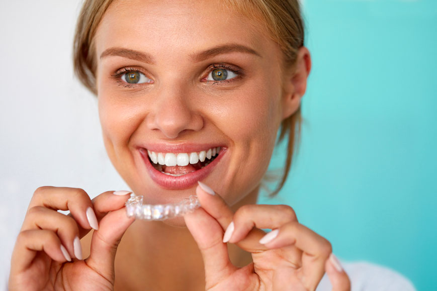 A Woman Trying To Wear Clear Invisalign Braces With A Smile