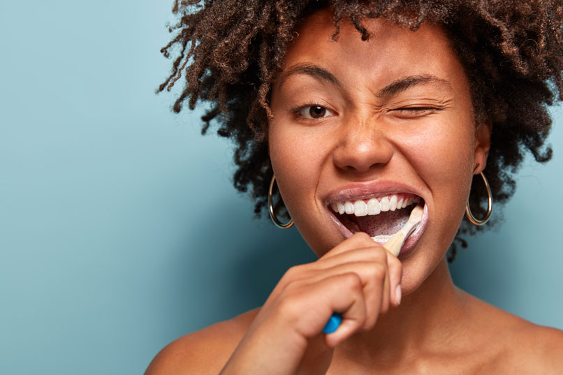 A Woman Brushing Her Teeth After Wisdom Teeth Removal