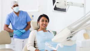 Woman Smiling While Sitting In A Dental Office