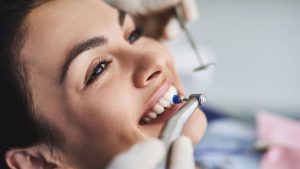 Woman Receiving Teeth Whitening Treatment At A Dental Office